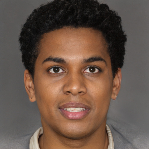 Joyful black young-adult male with short  brown hair and brown eyes