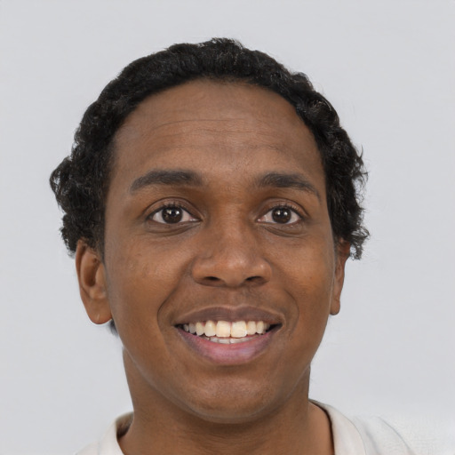 Joyful black young-adult male with short  black hair and brown eyes