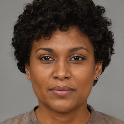 Joyful black adult female with short  brown hair and brown eyes
