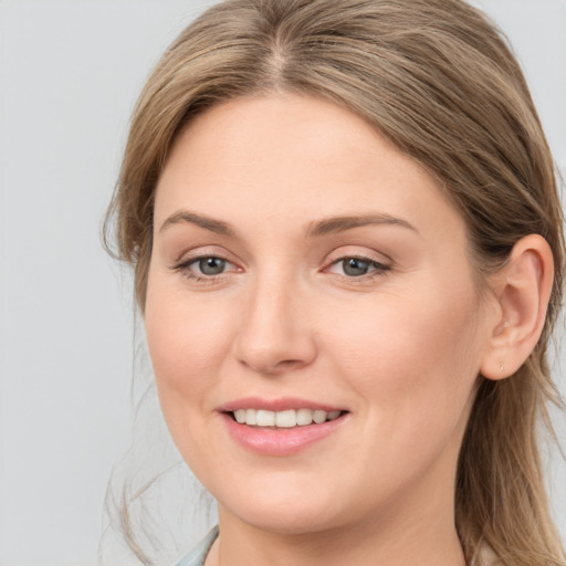 Joyful white young-adult female with medium  brown hair and grey eyes