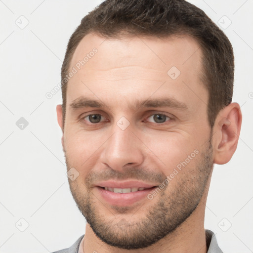 Joyful white young-adult male with short  brown hair and brown eyes