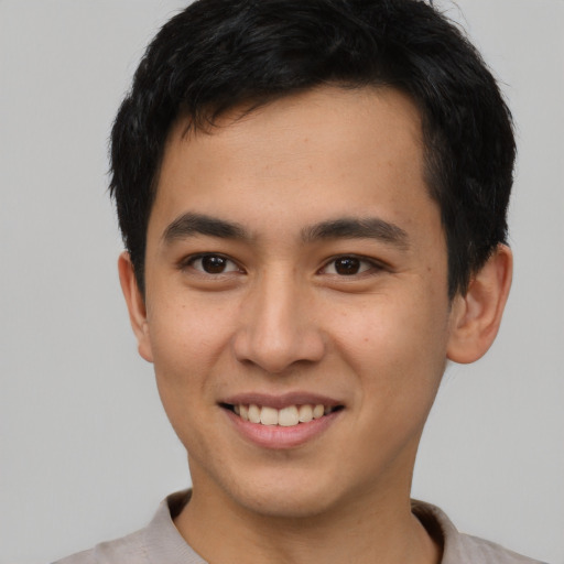 Joyful asian young-adult male with short  brown hair and brown eyes