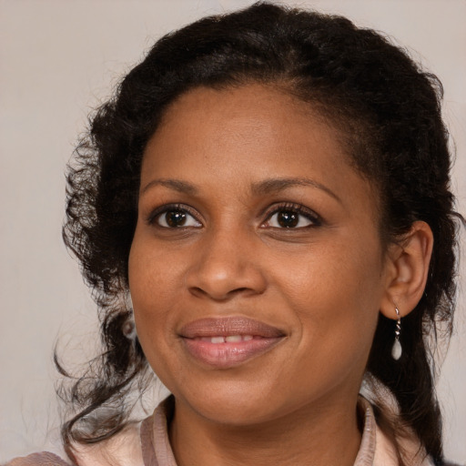 Joyful black adult female with medium  brown hair and brown eyes