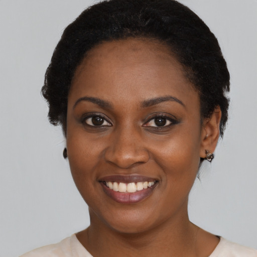 Joyful black young-adult female with medium  black hair and brown eyes