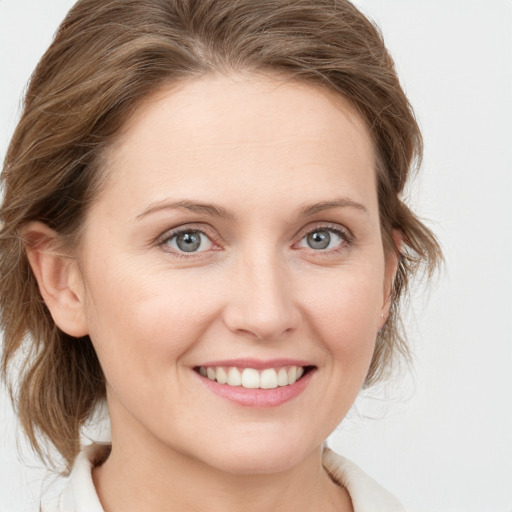 Joyful white young-adult female with medium  brown hair and blue eyes