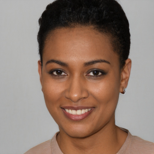 Joyful black young-adult female with short  black hair and brown eyes