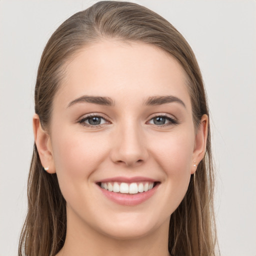 Joyful white young-adult female with long  brown hair and grey eyes