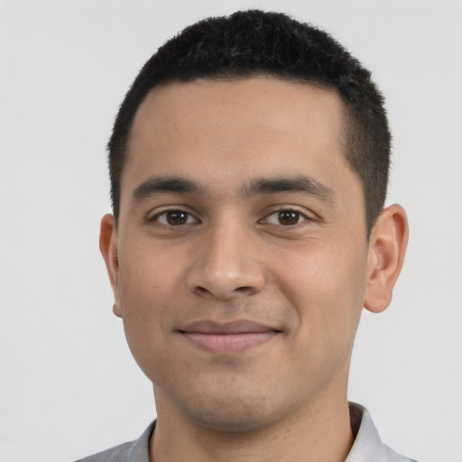 Joyful latino young-adult male with short  black hair and brown eyes