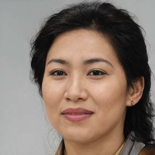 Joyful latino adult female with medium  brown hair and brown eyes