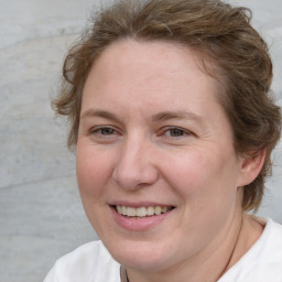 Joyful white adult female with medium  brown hair and blue eyes