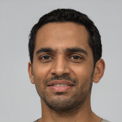 Joyful latino young-adult male with short  black hair and brown eyes