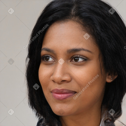 Joyful black young-adult female with long  black hair and brown eyes