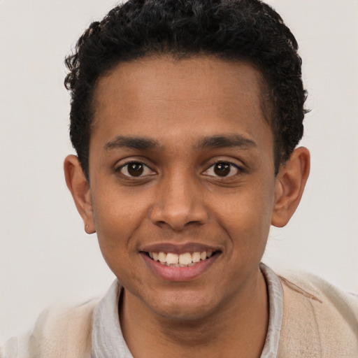 Joyful black young-adult male with short  brown hair and brown eyes