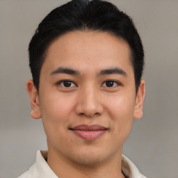 Joyful latino young-adult male with short  brown hair and brown eyes