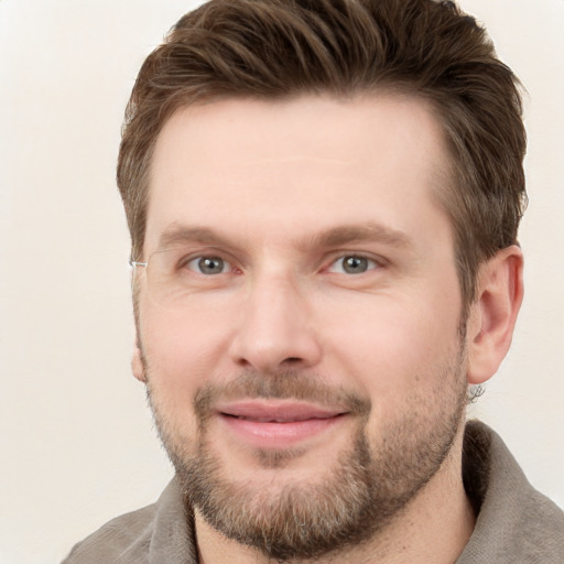 Joyful white young-adult male with short  brown hair and grey eyes