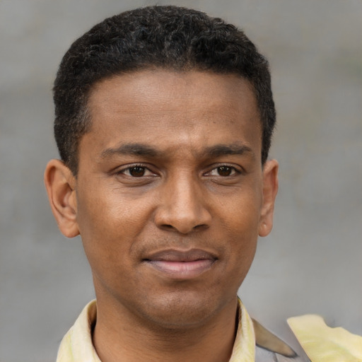 Joyful latino young-adult male with short  brown hair and brown eyes