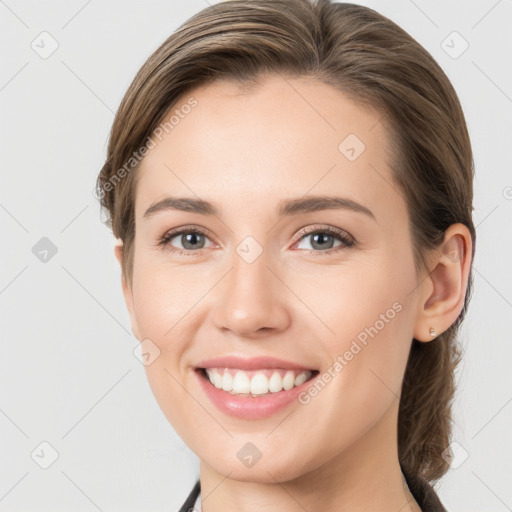 Joyful white young-adult female with medium  brown hair and grey eyes