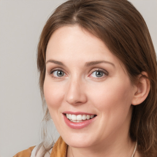 Joyful white young-adult female with medium  brown hair and blue eyes