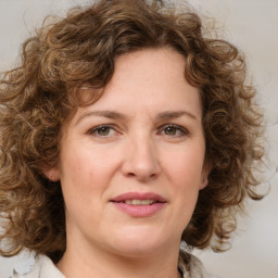 Joyful white young-adult female with medium  brown hair and green eyes