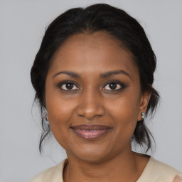 Joyful black adult female with medium  brown hair and brown eyes