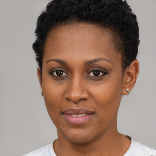 Joyful black young-adult female with short  black hair and brown eyes