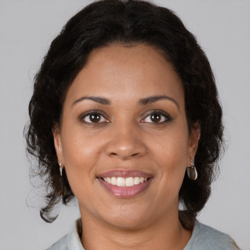 Joyful black young-adult female with medium  brown hair and brown eyes