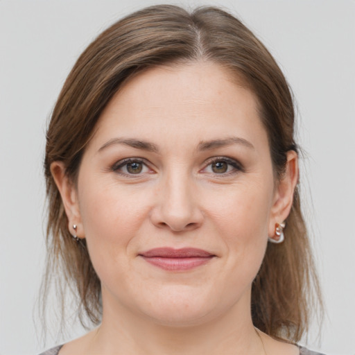 Joyful white young-adult female with medium  brown hair and grey eyes