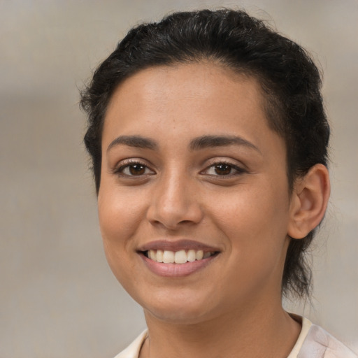 Joyful latino young-adult female with medium  brown hair and brown eyes