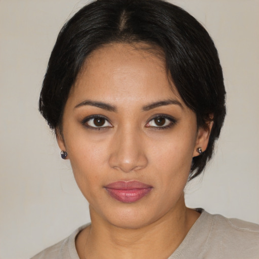 Joyful latino young-adult female with medium  brown hair and brown eyes