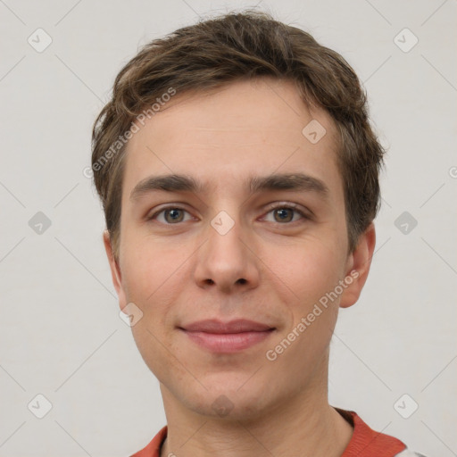 Joyful white young-adult male with short  brown hair and grey eyes