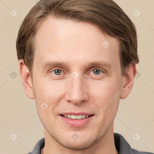 Joyful white young-adult male with short  brown hair and grey eyes