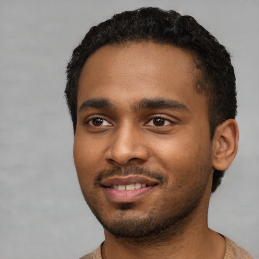 Joyful black young-adult male with short  black hair and brown eyes