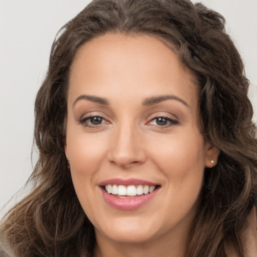 Joyful white young-adult female with long  brown hair and brown eyes