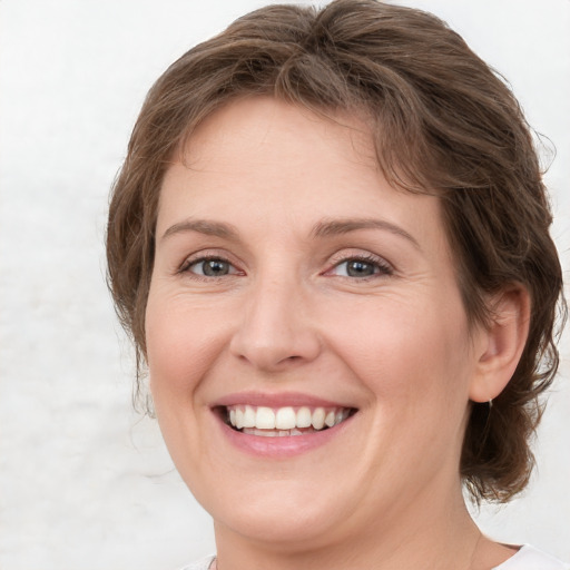 Joyful white adult female with medium  brown hair and blue eyes