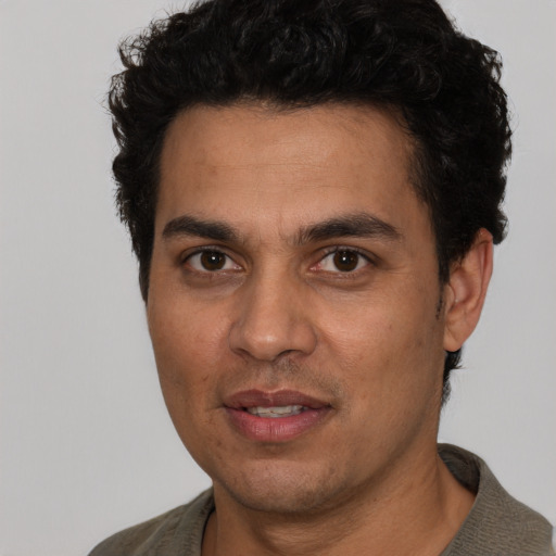 Joyful white adult male with short  black hair and brown eyes