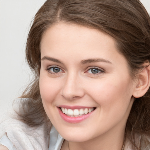 Joyful white young-adult female with medium  brown hair and blue eyes