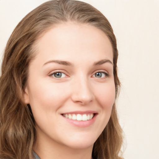 Joyful white young-adult female with long  brown hair and blue eyes