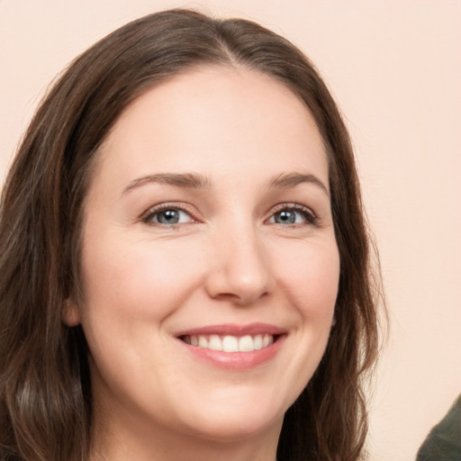 Joyful white young-adult female with long  brown hair and green eyes