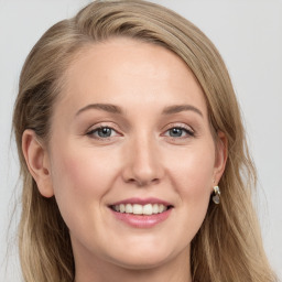 Joyful white young-adult female with long  brown hair and blue eyes