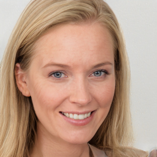 Joyful white young-adult female with long  brown hair and blue eyes