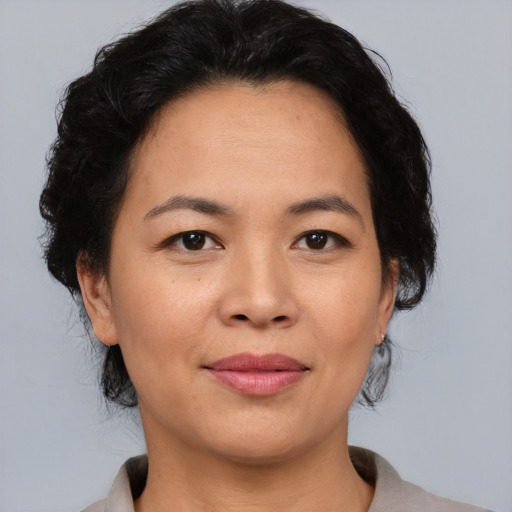 Joyful asian adult female with medium  black hair and brown eyes
