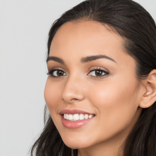 Joyful latino young-adult female with long  brown hair and brown eyes