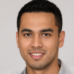 Joyful latino young-adult male with short  black hair and brown eyes