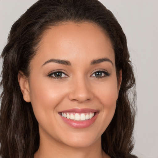 Joyful white young-adult female with long  brown hair and brown eyes