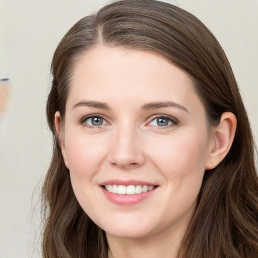 Joyful white young-adult female with long  brown hair and grey eyes