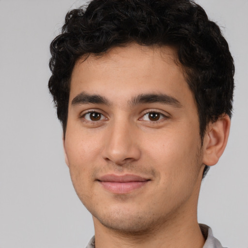 Joyful white young-adult male with short  black hair and brown eyes