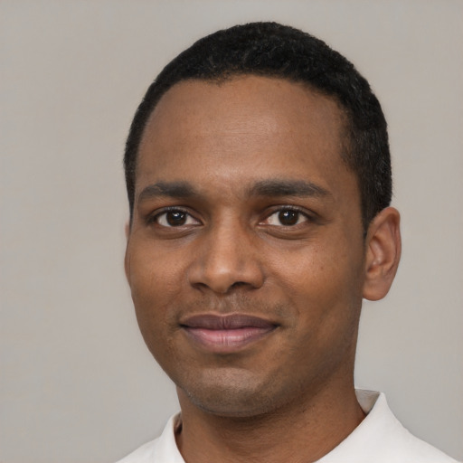 Joyful black young-adult male with short  black hair and brown eyes