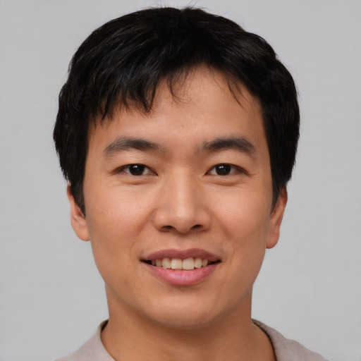 Joyful asian young-adult male with short  black hair and brown eyes