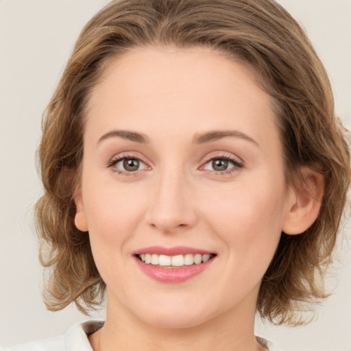 Joyful white young-adult female with medium  brown hair and green eyes