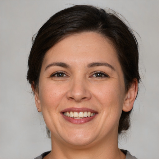 Joyful white adult female with medium  brown hair and brown eyes